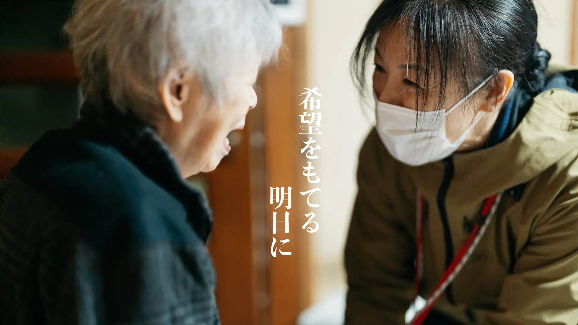 笑顔で介護するスタッフと高齢者